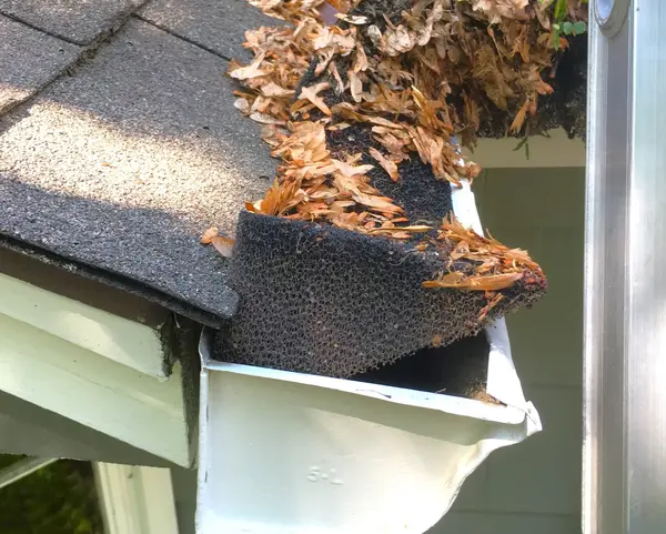 Deteriorated foam gutter guard - Need: 200x150px image showing old, debris-filled foam guard